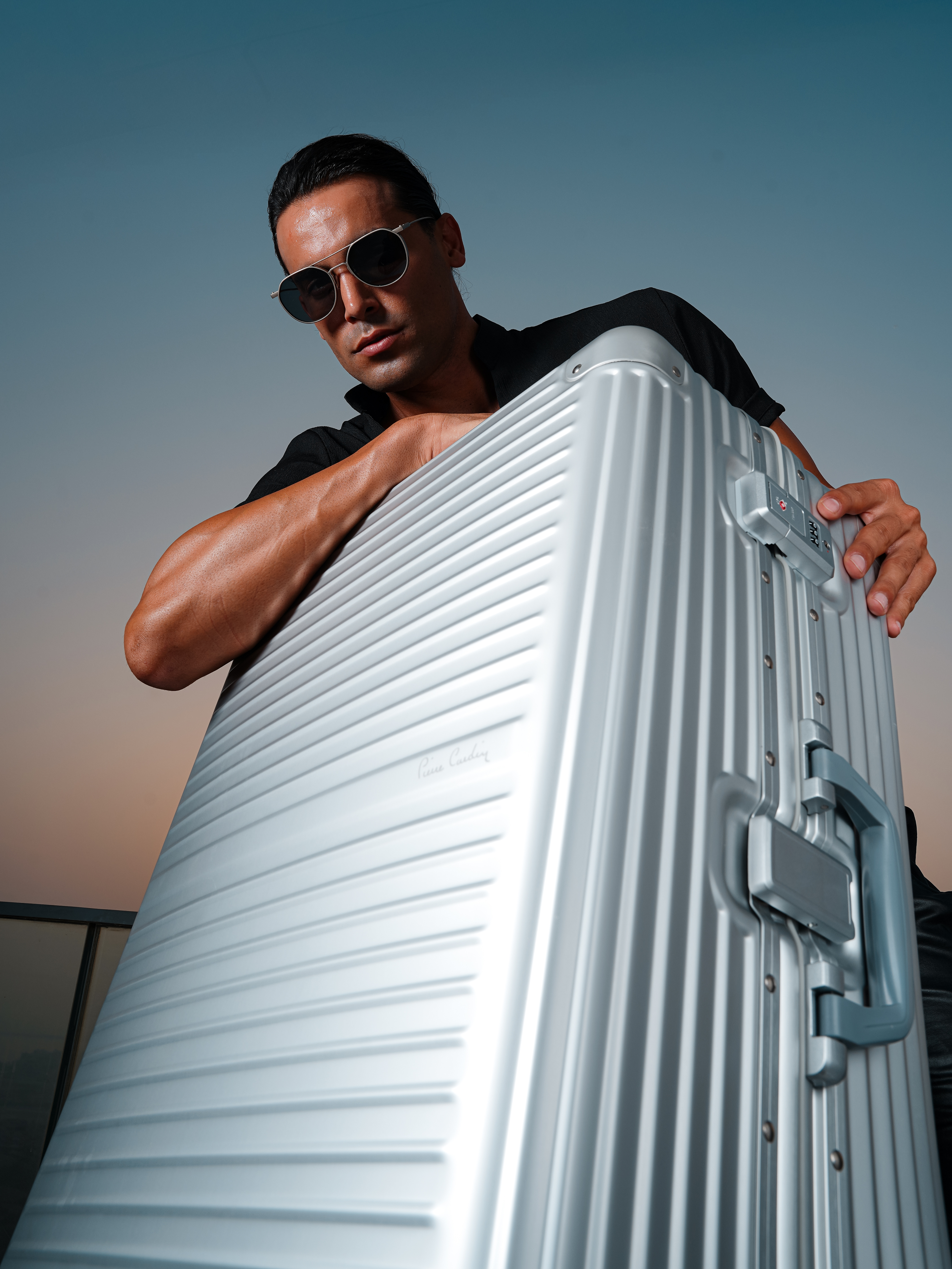 Model holding a silver Pierre Cardin Osaka suitcase.