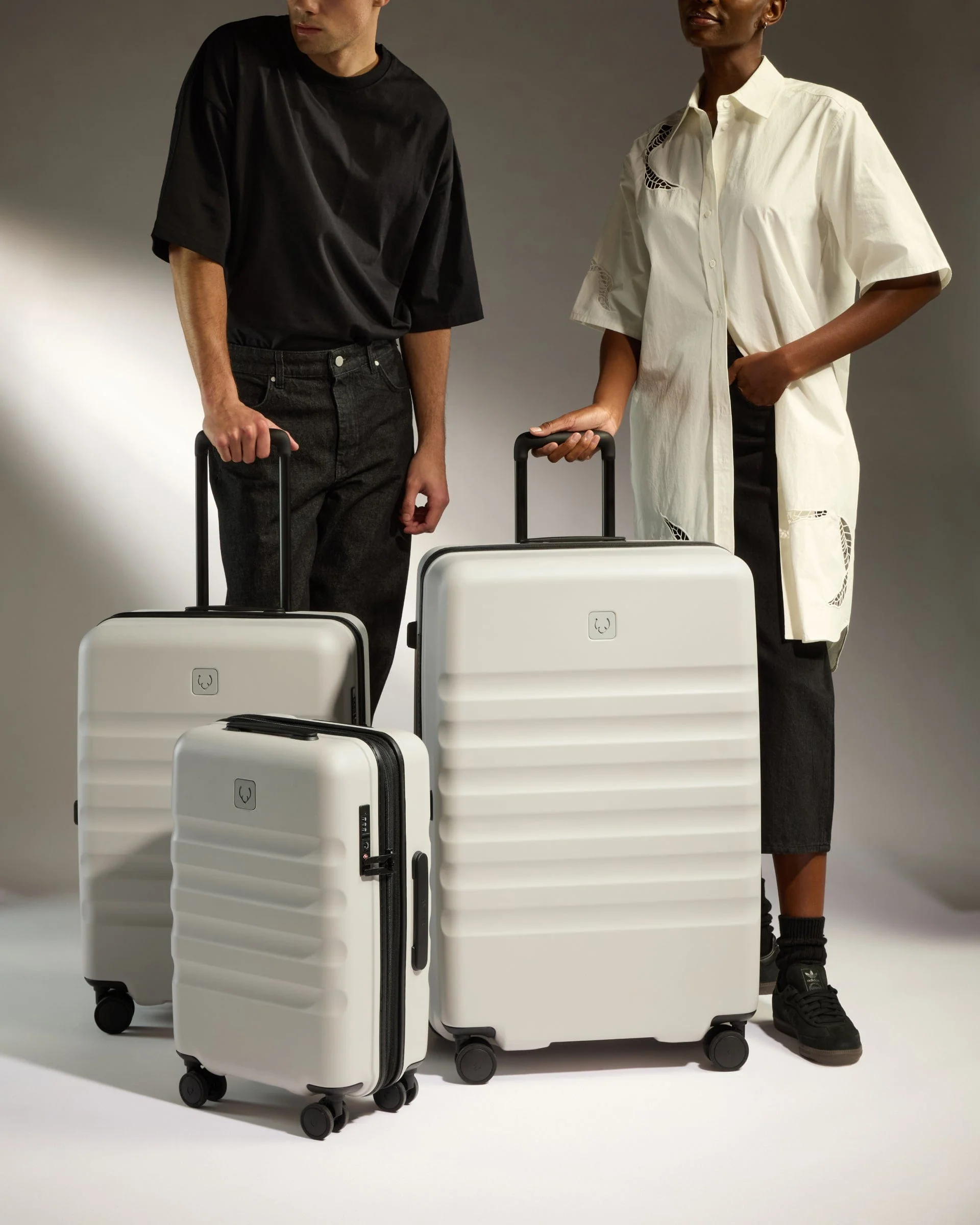Models with white Antler luggage in a studio setting.