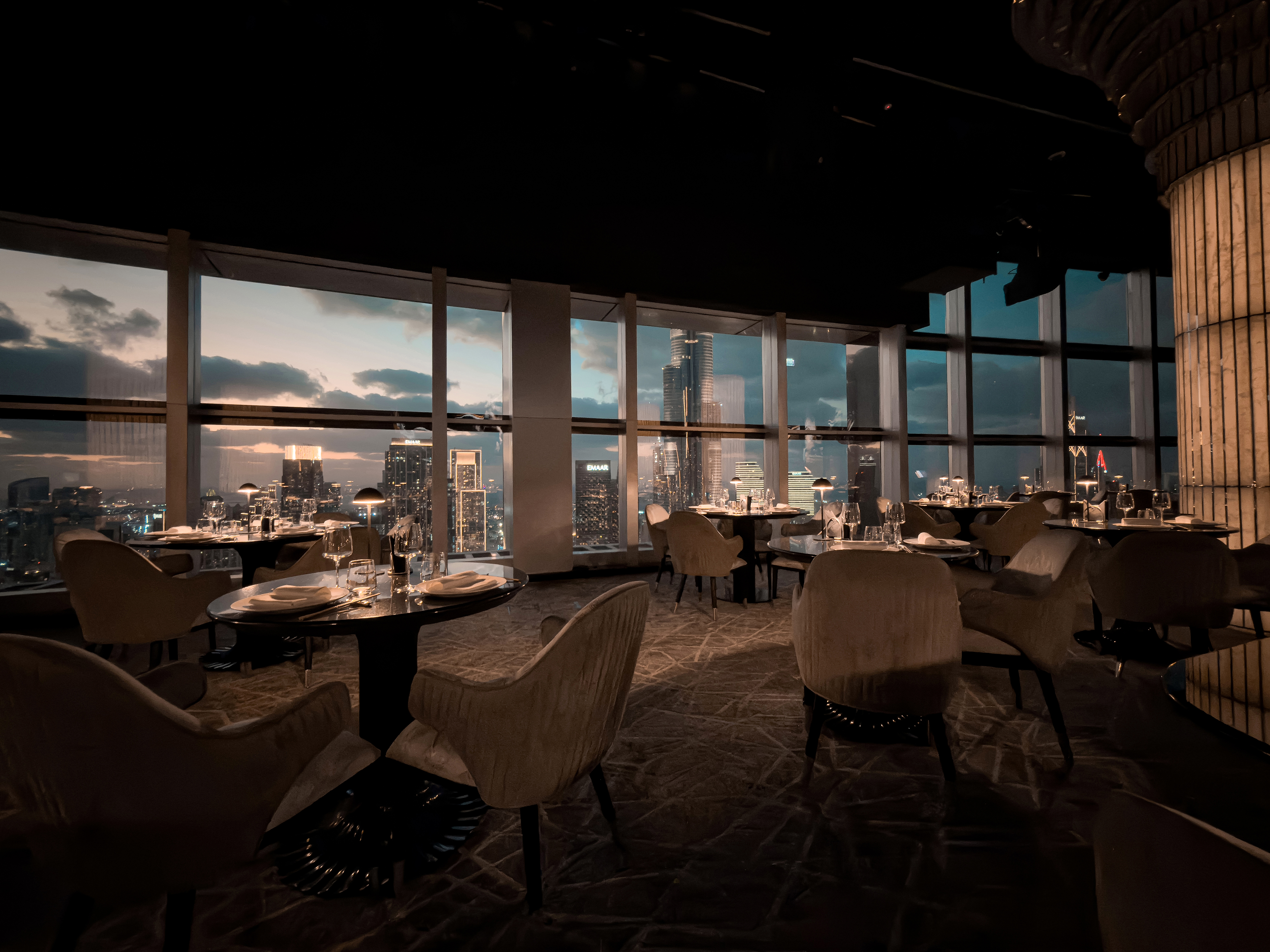 Dusk dining room at BIRDS Dubai with Burj Khalifa skyline view.