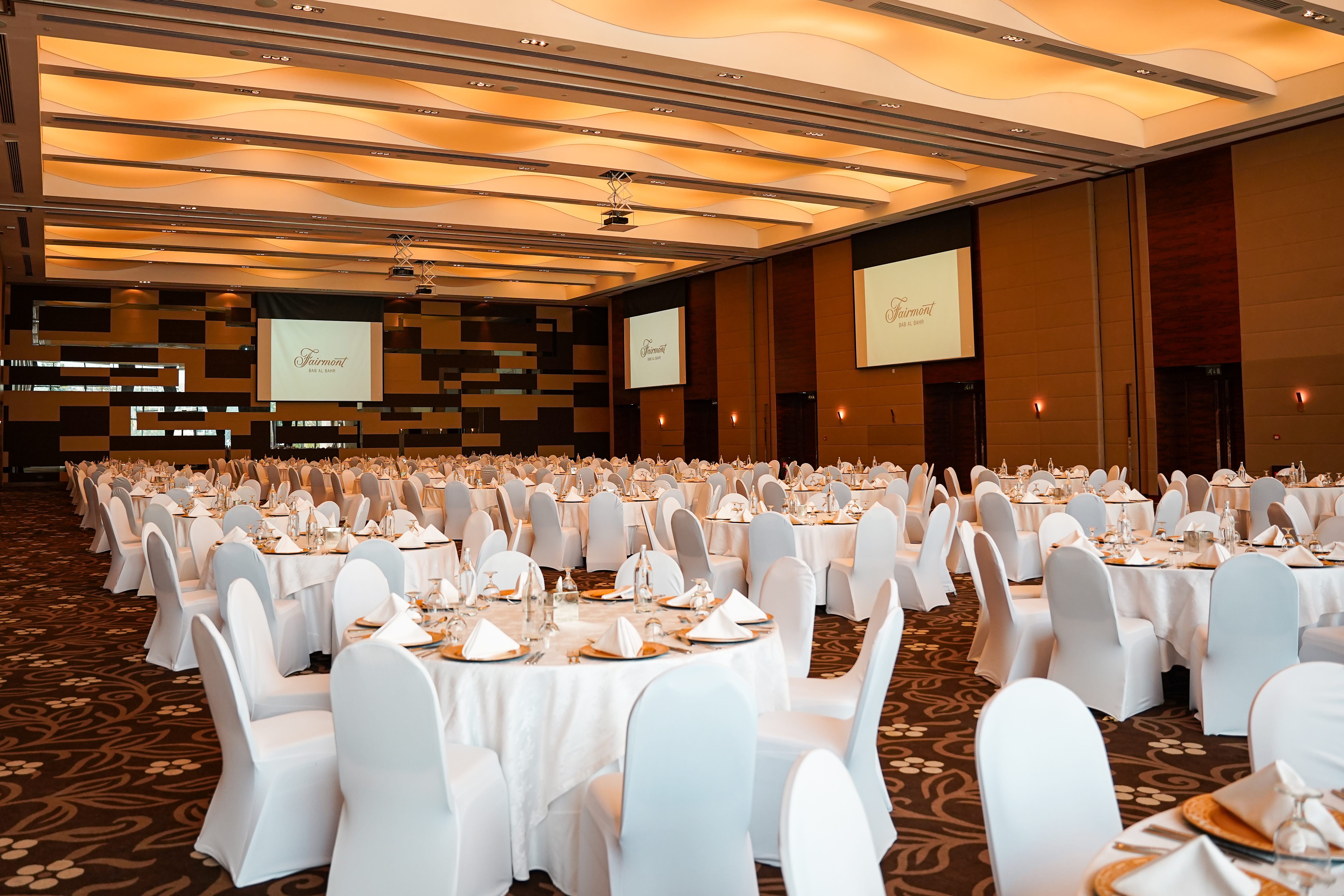 Fairmont ballroom with banquet tables and presentation screens.