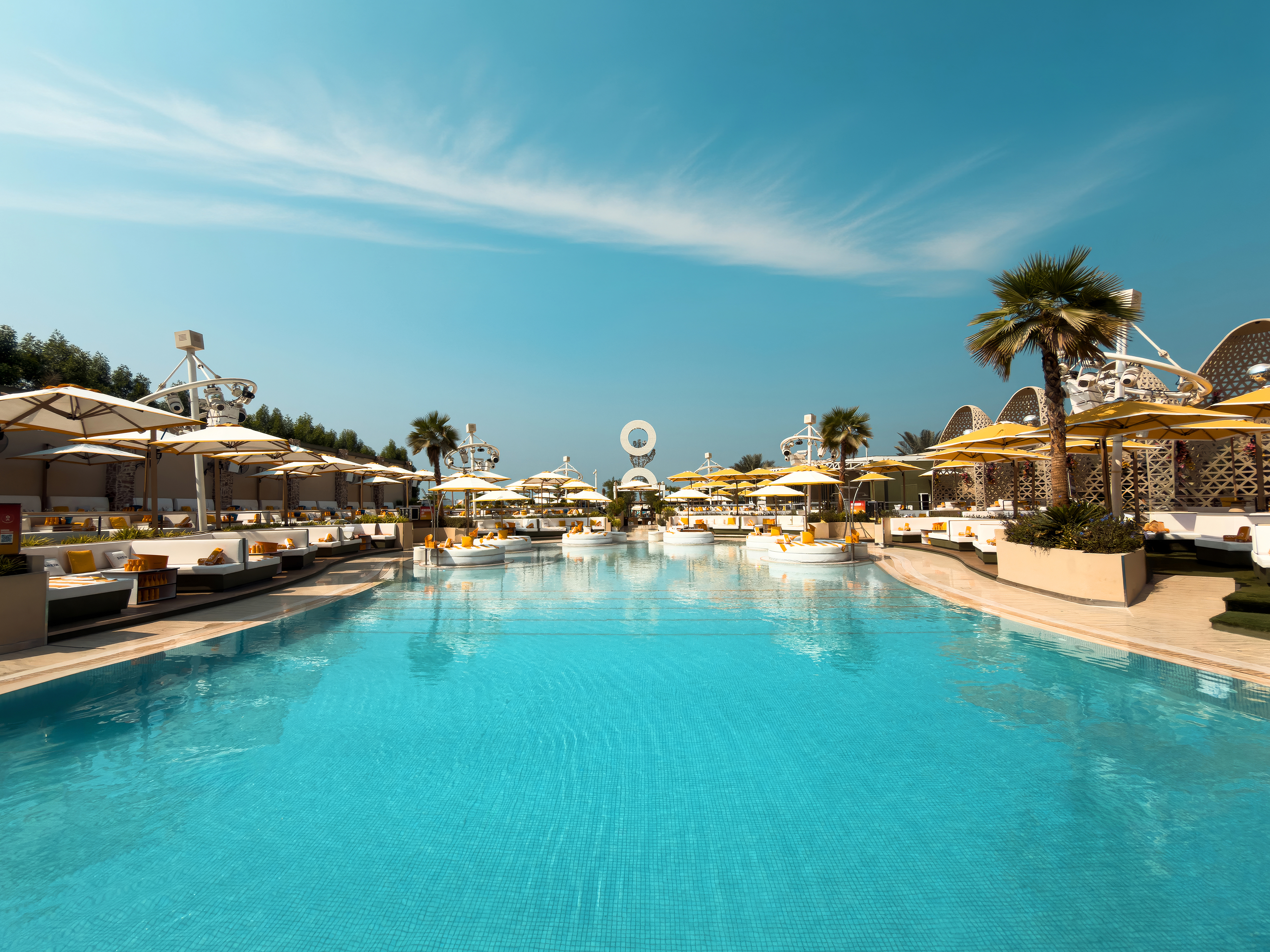 Wide poolside view at O Beach Dubai with cabanas and blue water.