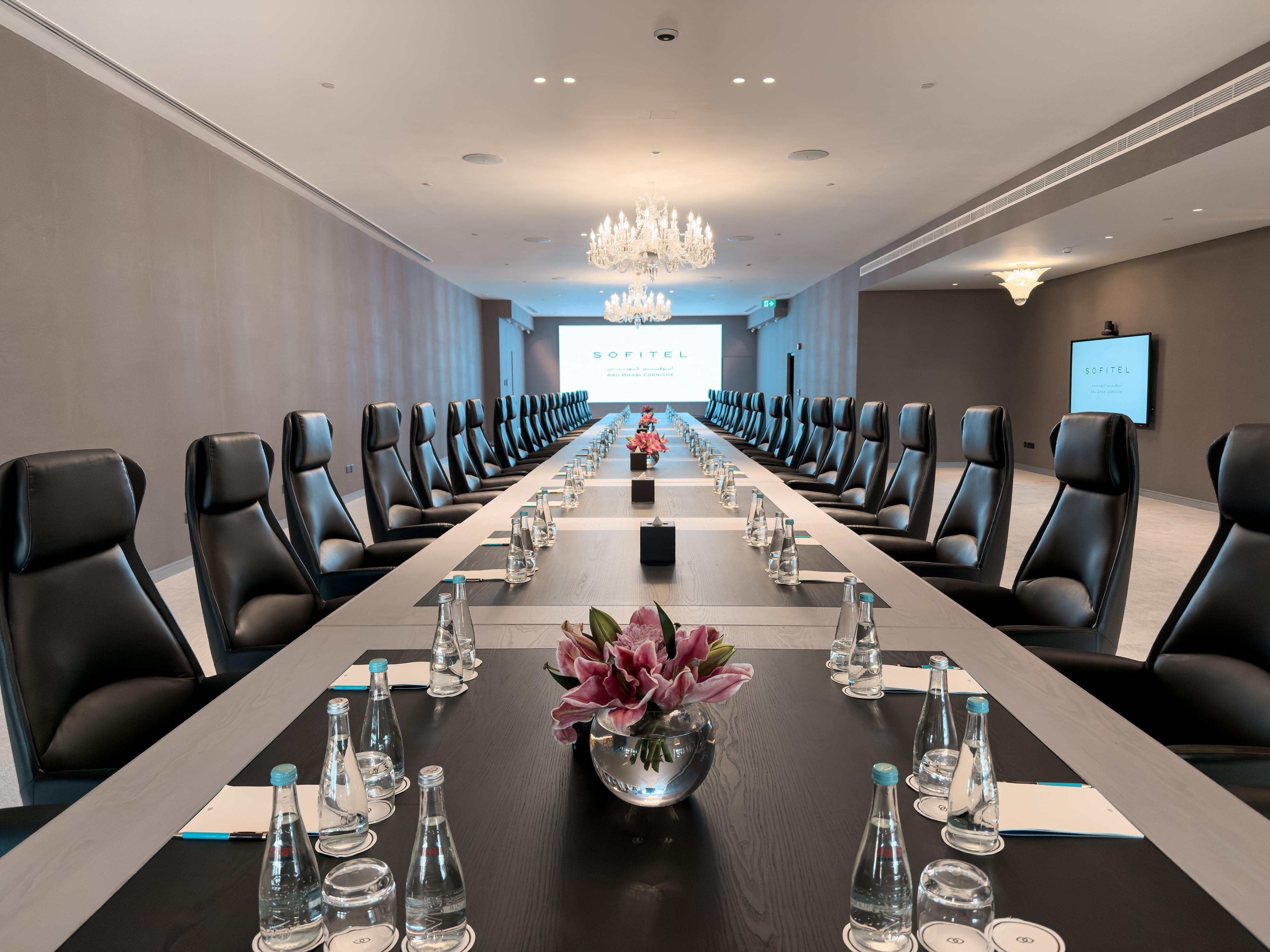 Executive boardroom at Sofitel Abu Dhabi Corniche with branded presentation screen.