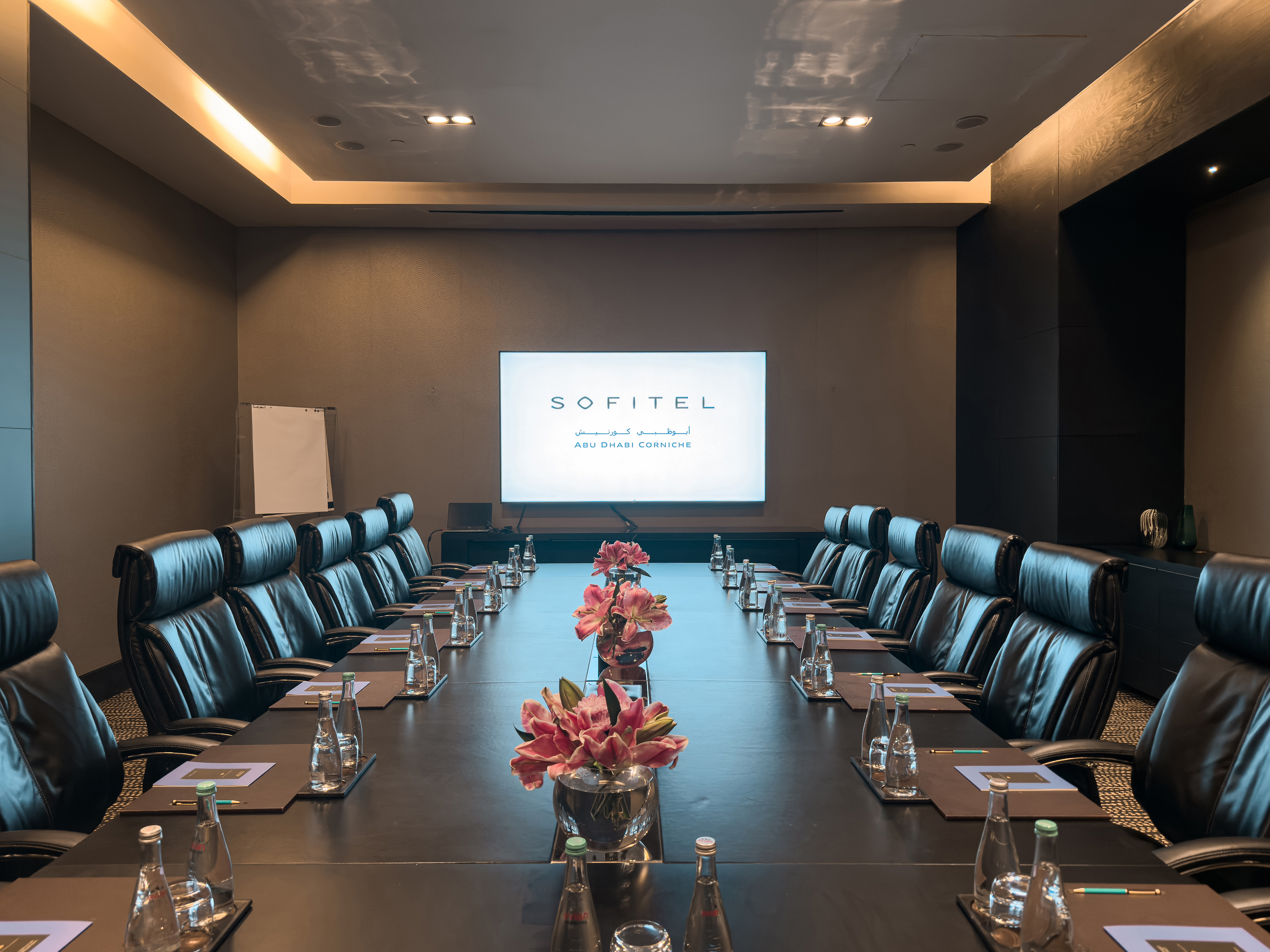 Executive boardroom at Sofitel Abu Dhabi Corniche with flower arrangement.