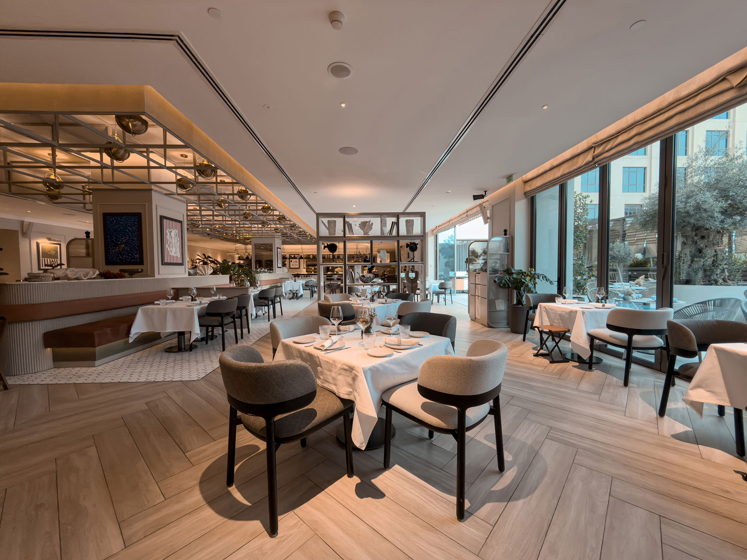 Vera Versilia main dining room with set tables and warm interior lighting.